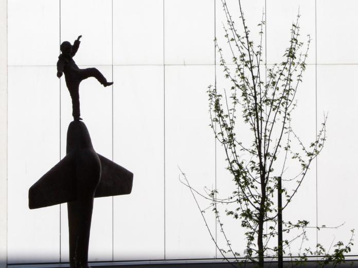 Skulptur af mand der balancerer på en flyver